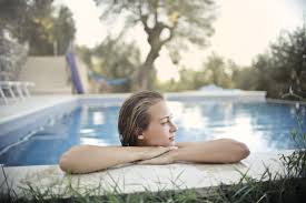 Persona relajándose junto a la piscina